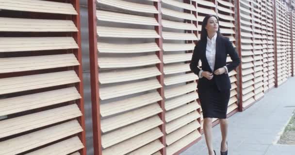 Businesswoman in hurry walking alongside building — Stock Video