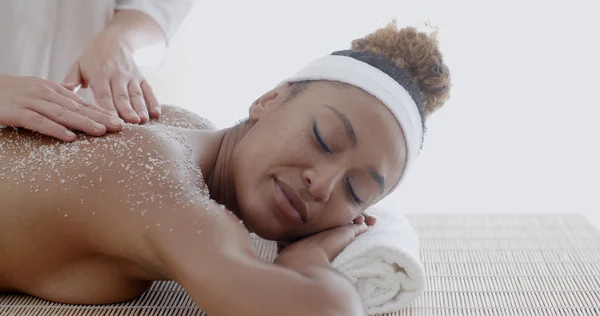 Mujer recibiendo tratamiento de exfoliación con sal — Foto de Stock