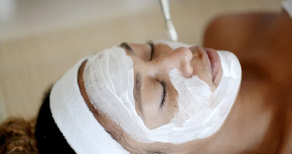 Cosmetician aplicando máscara facial para a mulher — Fotografia de Stock