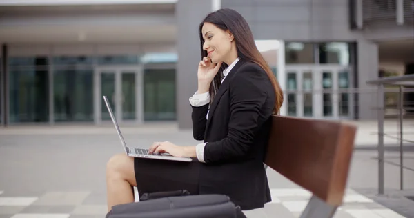 Femme d'affaires travaillant sur ordinateur portable sur banc à l'extérieur — Photo