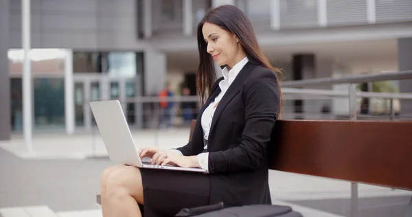 Femme d'affaires travaillant sur ordinateur portable sur banc à l'extérieur — Photo