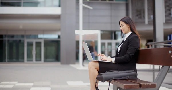 Бізнес-леді працює на ноутбуці на лавці на відкритому повітрі — стокове фото