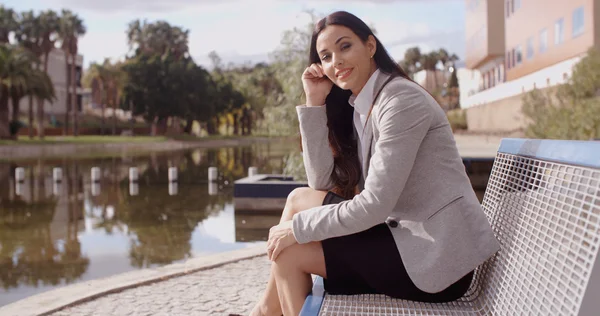 Business woman sitting on bench near canal — стоковое фото