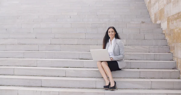Zakenvrouw zittend op de marmeren trap met laptop — Stockfoto