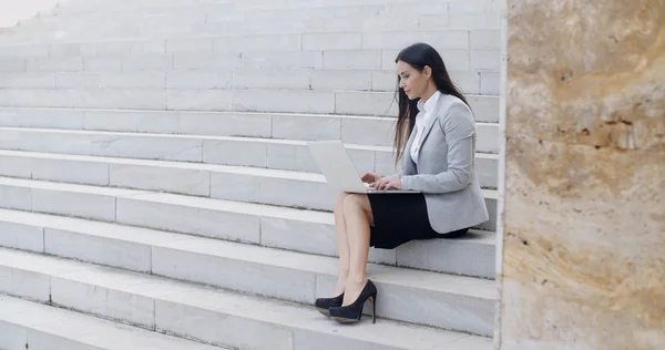 Zakenvrouw zittend op de marmeren trap met laptop — Stockfoto