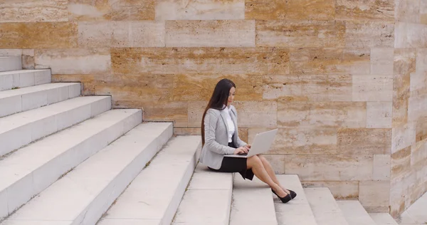 Liikenainen istuu marmori portaikko kannettava tietokone — kuvapankkivalokuva