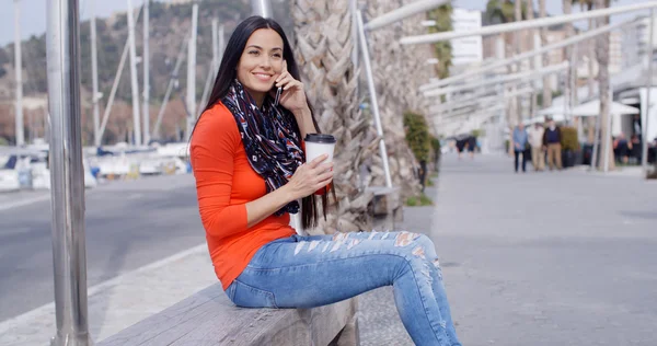 Frau plaudert auf Bank mit Handy — Stockfoto