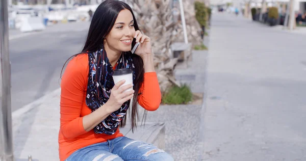 Woman chatting on mobile phone on bench — Stok fotoğraf