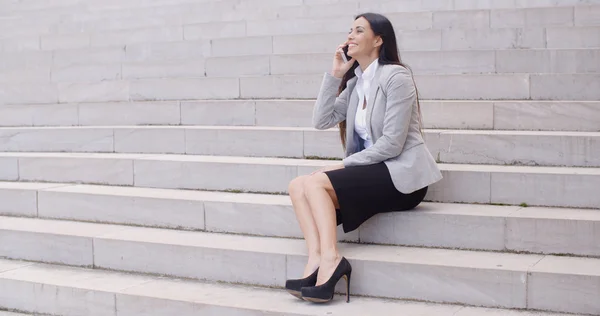 Businesswoman on marble stairs talking on phone — 스톡 사진