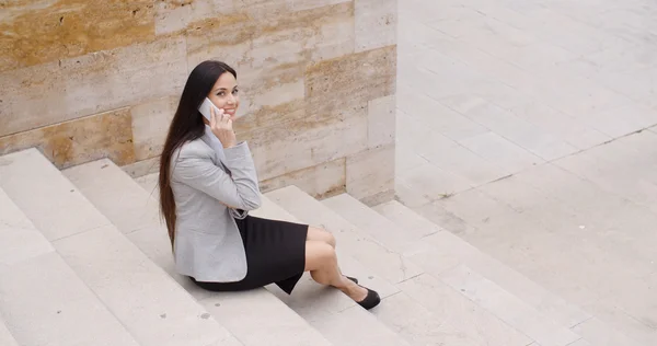 Businesswoman on marble stairs talking on phone — Stock fotografie