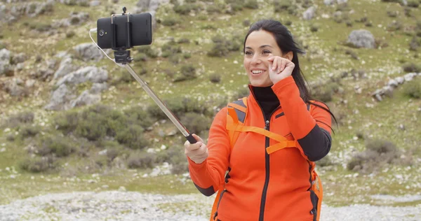 Sac à dos femelle en utilisant selfie stick — Photo