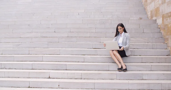 Zakenvrouw zittend op de marmeren trap met laptop — Stockfoto