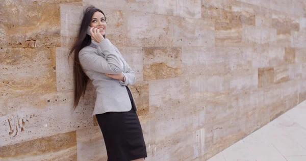 Femme d'affaires parlant au téléphone et se penchant sur le mur — Photo