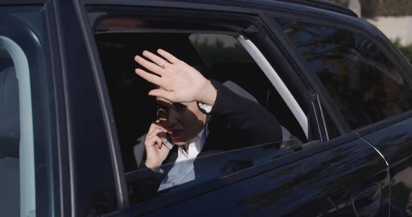 Executive in car blocking view from window — Stockfoto