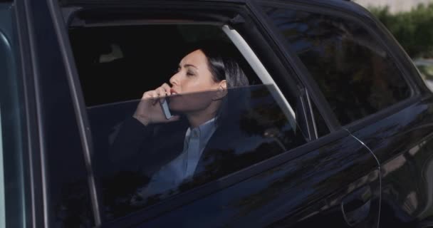 Деловая женщина разговаривает по телефону в лимузине — стоковое видео