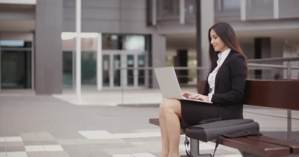 Femme d'affaires travaillant sur ordinateur portable sur banc à l'extérieur — Video