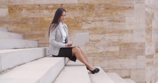 Mujer de negocios sentada en una escalera de mármol con portátil — Vídeo de stock