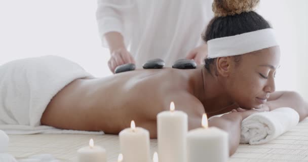 Жінка отримує масаж гарячими каменями — стокове відео