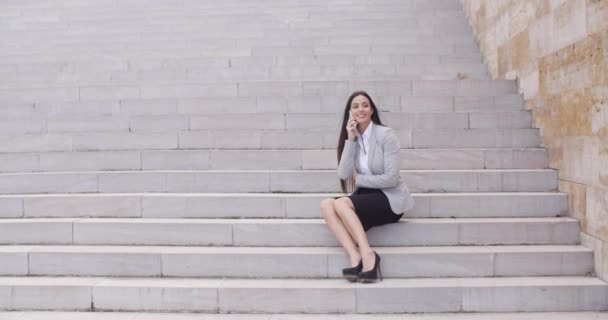 Businesswoman on marble stairs talking on phone — ストック動画