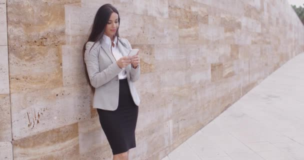 Businesswoman leaning wall and using phone — 비디오