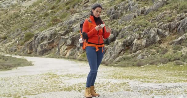 Woman hiking in mountains and checking map — Stock Video