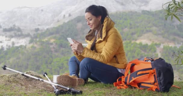 Caminhante feminino usando telefone em montanhas — Vídeo de Stock