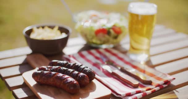 Grilled sausages and glass of beer — Stock Video