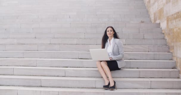 Businesswoman sitting on marble staircase with laptop — Stock Video