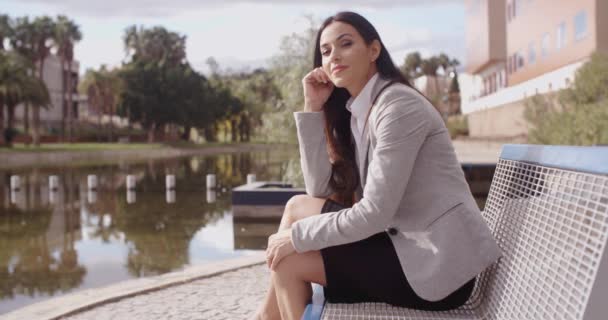 Businesswoman sitting on bench near canal — Stock Video