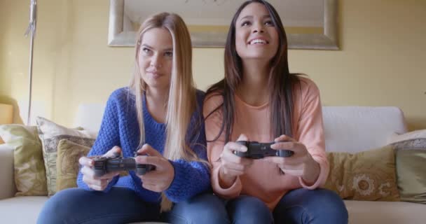 Женщины играют в видеоигры на диване — стоковое видео