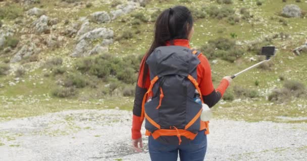Жіночий рюкзак використовує палицю селфі — стокове відео