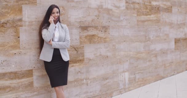 Mujer de negocios hablando por teléfono y apoyándose en la pared — Vídeos de Stock