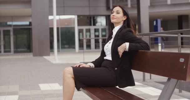 Business woman sitting alone on bench — стоковое видео