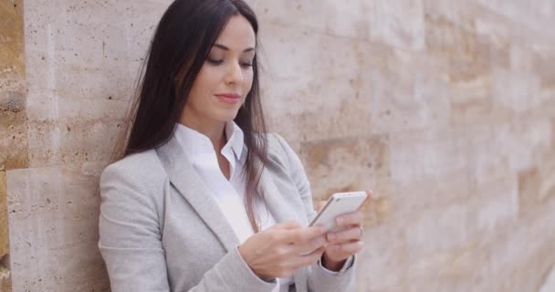 Mujer de negocios apoyado en la pared y el uso de teléfono — Vídeos de Stock