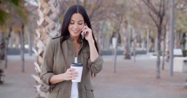 Kobieta spaceru w parku i rozmowy na telefon komórkowy — Wideo stockowe