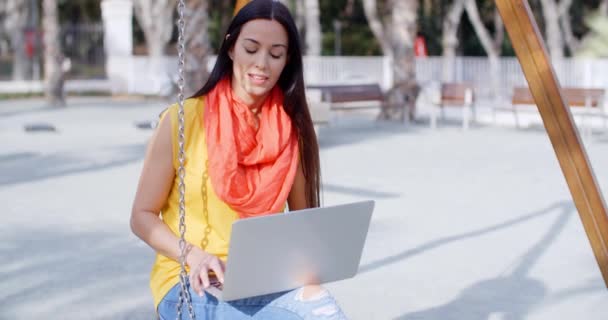 Mujer sentada en columpio y trabajando en portátil — Vídeos de Stock