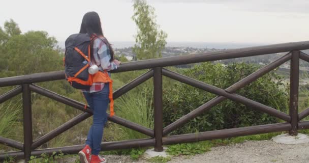 Mujer con mochila admirando el paisaje — Vídeo de stock