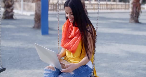 Mulher sentada no balanço e trabalhando no laptop — Vídeo de Stock