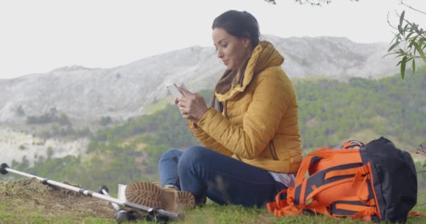 Female hiker using phone in mountains — Αρχείο Βίντεο