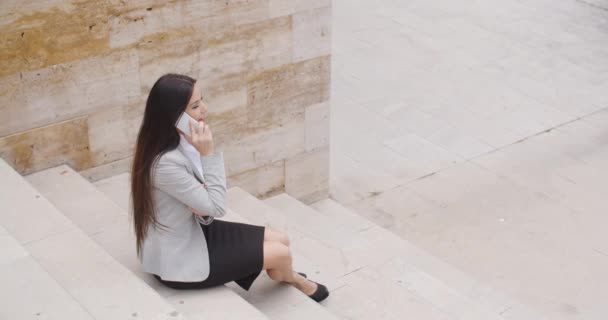 Businesswoman on marble stairs talking on phone — Stockvideo