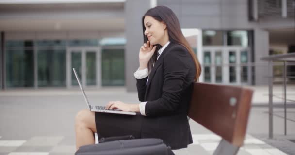 Affärskvinna arbetar på bärbar dator på bänk utomhus — Stockvideo