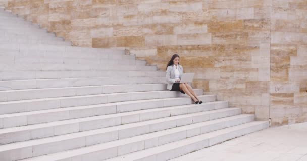 Femme d'affaires assise sur un escalier en marbre avec ordinateur portable — Video