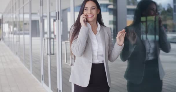 Деловая женщина разговаривает по телефону за пределами офиса — стоковое видео