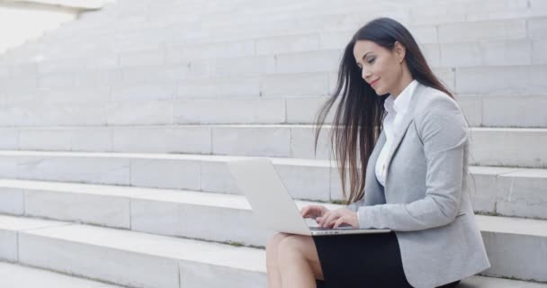 Businesswoman sitting on marble staircase with laptop — Stock Video