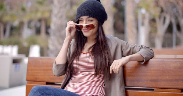 Woman sitting daydreaming on park bench — Stock Photo, Image