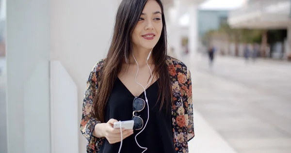 Frau zu Fuß und hört Musik über Kopfhörer — Stockfoto
