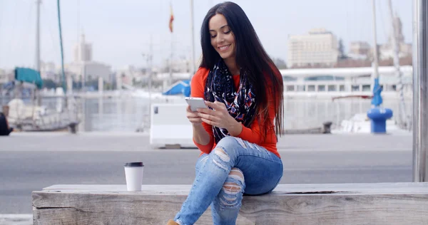 Mulher sentada no banco com telefone móvel — Fotografia de Stock