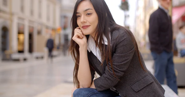 Vrouw zitten in de stad — Stockfoto