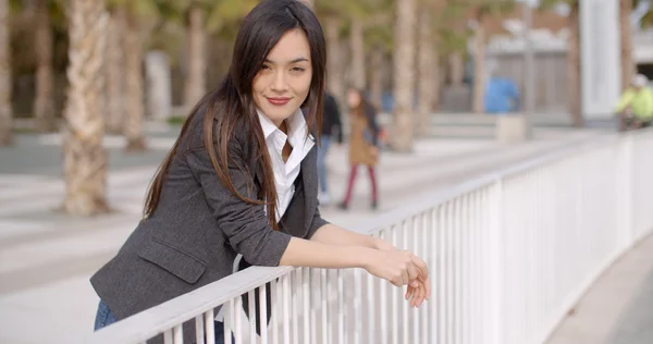 Woman leaning on white metal railing — Stock Photo, Image