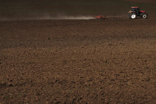 Trekker ploegen het veld — Stockfoto